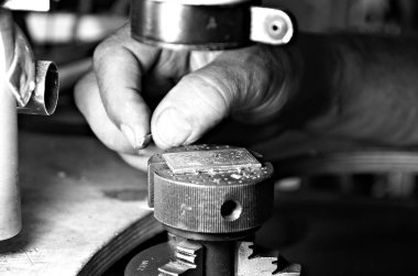 Erkeklerin elleri metal bir parça tutuyor, metal işleme ve oyma, kapat.