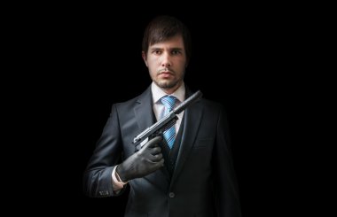Hitman ya da siyah arka plan üzerinde susturucu ile tabanca ile katil. Düşük tuş fotoğrafı.