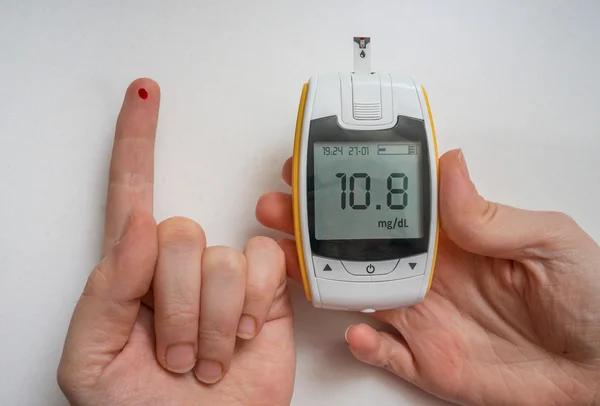 Διαβητικός ασθενής χρησιμοποιεί glucometer να ελέγξετε το επίπεδο της γλυκόζης. Αίμα στο δάκτυλο. — Φωτογραφία Αρχείου