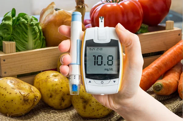 El Glikoz seviyesi ölçümü için şeker ölçüm tutar. Sebze arka planda. Diyabetik Diyet ve diyabet kavramı. — Stok fotoğraf