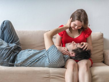 Genç çift kanepede rahatlatıcı ve dokunaklı. Aşk kavramı.