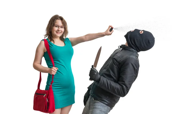 Selbstverteidigungskonzept. Junge Frau wehrt sich mit Pfefferspray gegen Räuber mit Messer isoliert auf weißem Hintergrund. — Stockfoto