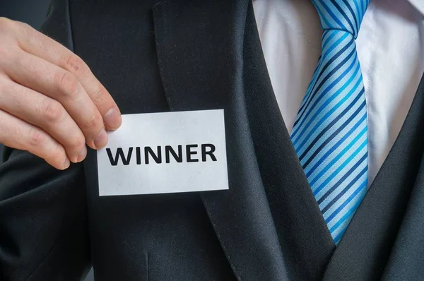 Homem de terno está mostrando etiqueta que Ele é um vencedor . — Fotografia de Stock