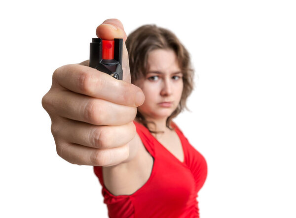 Young woman holds pepper spray in hand. Self defense concept. Isolated on white background.