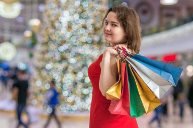Genç kadın hediyeleri Noel için alışveriş merkezinde alışveriş.