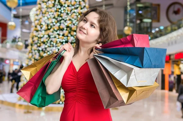 Молодая женщина делает покупки подарки на Рождество и держит много красочных мешков . — стоковое фото