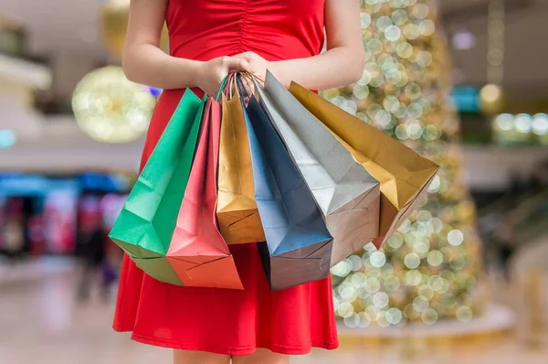 Молодая женщина держит в руках много сумок для покупок. Рождественские покупки . — стоковое фото