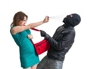 Self defense concept. Young woman is defending with pepper spray against thief or burglar. Isolated on white background. clipart