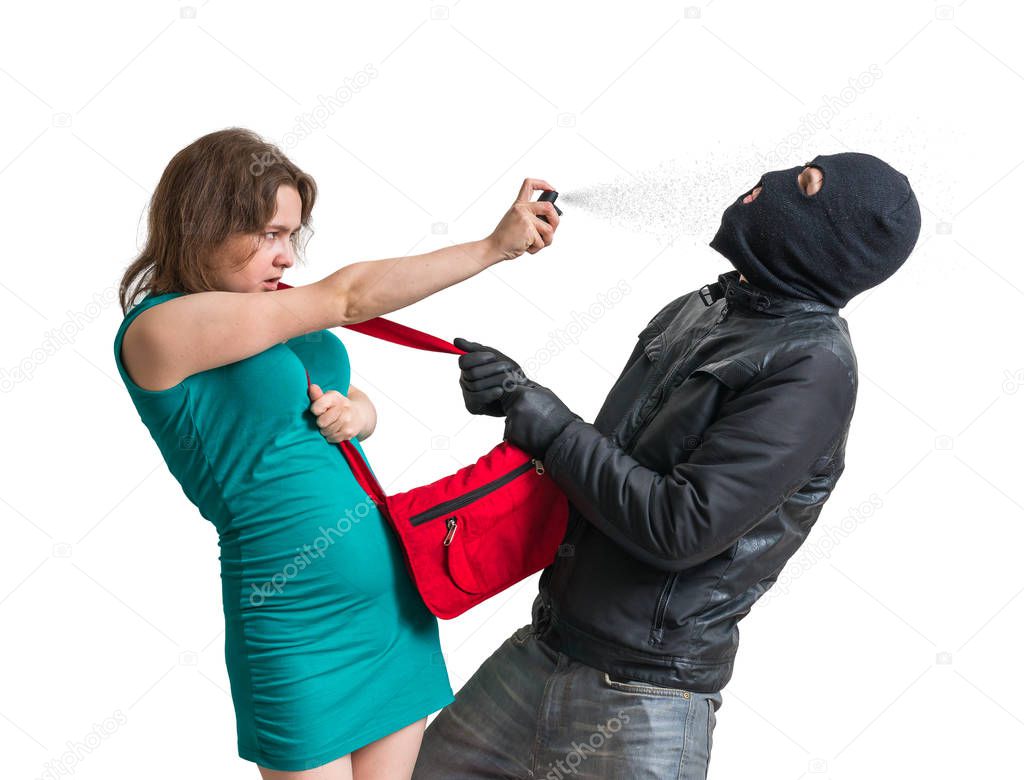 Self defense concept. Young woman is defending with pepper spray against thief or burglar. Isolated on white background.