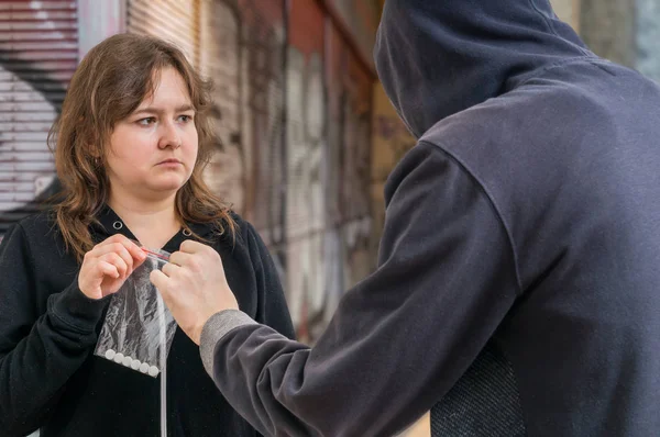 Jeune femme accro prend des pilules blanches du dealer de drogue . — Photo