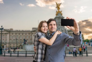 Genç mutlu çift Londra'da Buckingham palace yakınındaki selfie fotoğraf çekme.