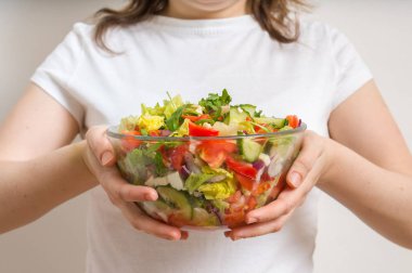 Genç vejetaryen kadın kase sebze salatası tam tutar.