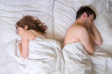 Çatışma ve ilişki zorluklar kavramı. Çift başa birbirlerine yatakta uyuyor.