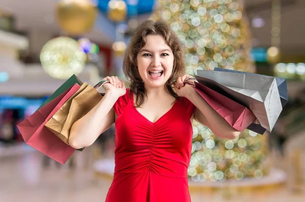 Молодая веселая женщина покупает рождественские подарки . — стоковое фото