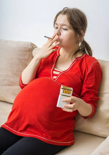 Rökning under graviditet. Gravid kvinna håller cigarett i handen. — Stockfoto