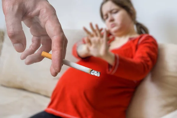 Concepto pasivo de fumar. Hombre egoísta está fumando cigarrillo cerca de la mujer embarazada . —  Fotos de Stock