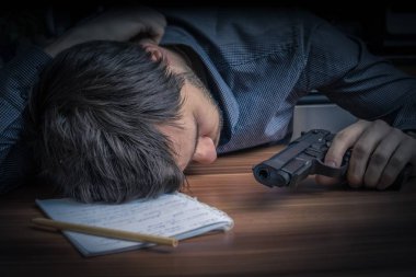 Üzgün bir adam elinde intihar düşünürken tabanca tutan.