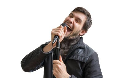 Karaoke kavramı. Genç adam mikrofon ve şarkı şarkı tutar. Beyaz arka plan üzerinde izole.