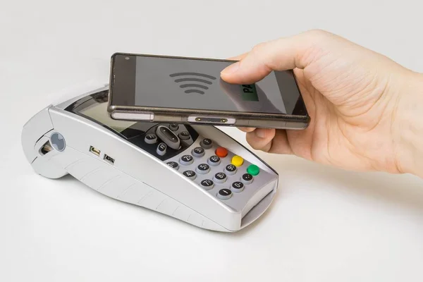 Pelanggan membayar dengan smartphone menggunakan teknologi NFC dan terminal pembayaran . — Stok Foto