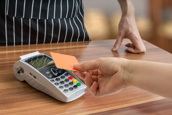 Le client paie avec une carte de crédit sans contact dans la boutique . — Photo