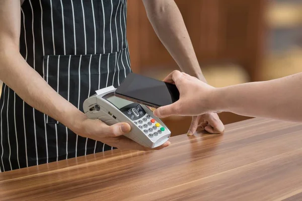 El cliente está pagando con teléfono inteligente en la tienda utilizando la tecnología NFC . — Foto de Stock