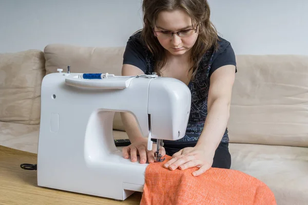 Young woman is sewing cloth with sewing machine. — Stock Photo, Image