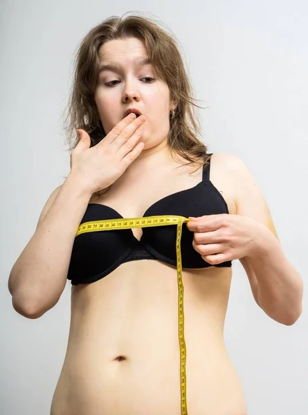 Молода жінка шокована після вимірювання її розміру грудей . — стокове фото