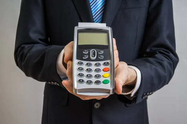 Empresário detém terminal de pagamento em mãos . — Fotografia de Stock