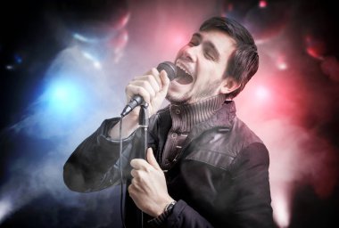 Mutlu genç adam geceleri disko kulüpte şarkı söylerken.