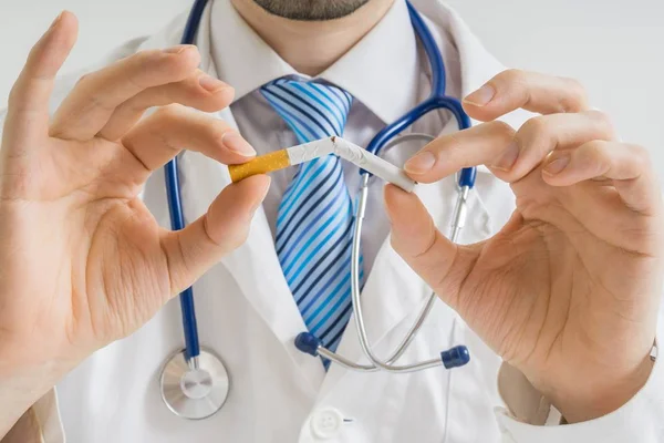 El doctor está rompiendo el cigarrillo y dando consejos para dejar de fumar. . — Foto de Stock