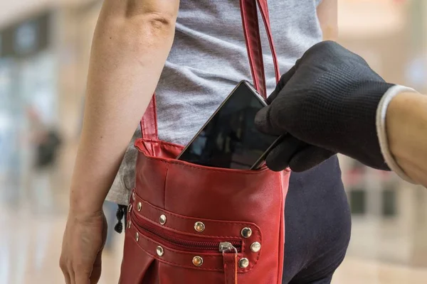Вор из кармана крадет смартфон из красной сумочки . — стоковое фото