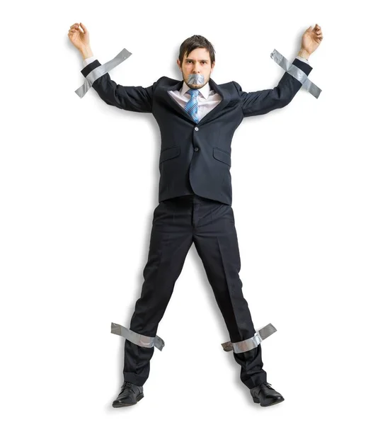 Бизнесмен в костюме приклеен клейкой лентой к стене. Изолированный на белом фоне . — стоковое фото