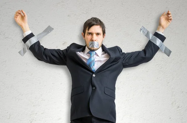 Επιχειρηματίας στο κοστούμι είναι μαγνητοσκοπημένο στον τοίχο με κολλητική ταινία. — Φωτογραφία Αρχείου