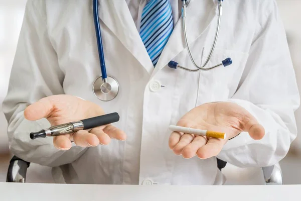 Arzt vergleicht elektronischen Verdampfer mit herkömmlicher Tabakzigarette. — Stockfoto