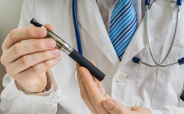 医師が電子タバコまたは気化器の健康への影響を分析します。. — ストック写真