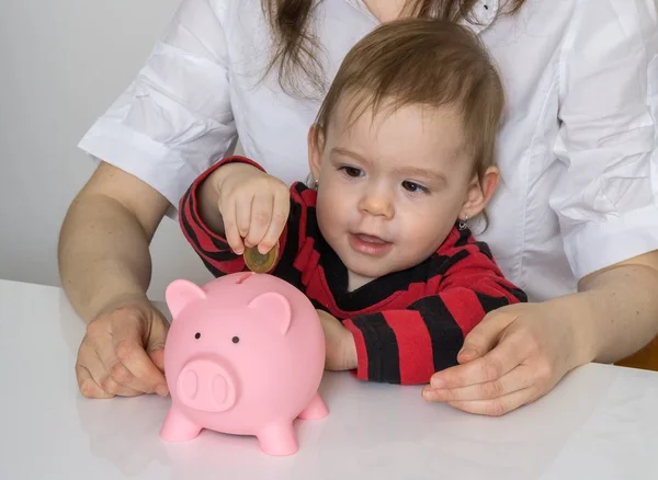 Savings for future. Little girl is putting coins in piggy money bank. — Stock Photo, Image