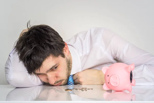 Jovem preocupado homem tem vazio porquinho dinheiro banco . — Fotografia de Stock