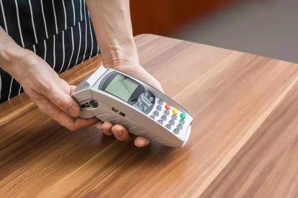Verkäufer hält Zahlungsterminal in den Händen. — Stockfoto