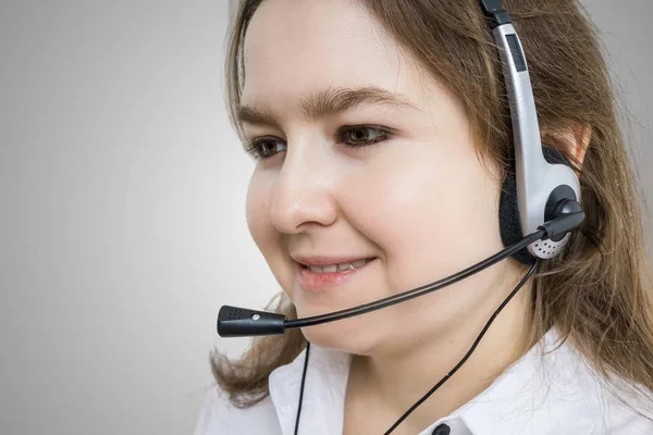 电话营销和客户服务理念。微笑的年轻女子-运算符灰色背景. — 图库照片