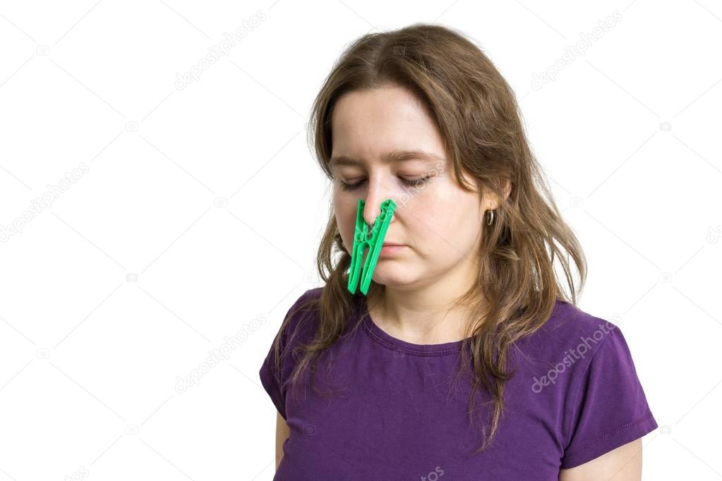 Pollen allergy concept. Young woman cant breathe and wearing peg on her nose. Isolated on white background.