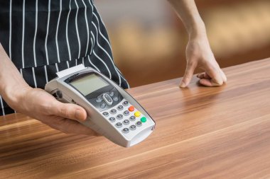 Satıcı ödeme terminal elinde tutan.