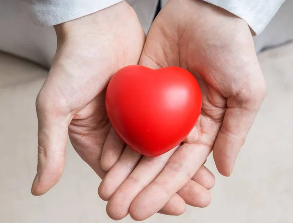 Herztransplantationskonzept. Arzt hält rotes Herz in Händen. — Stockfoto