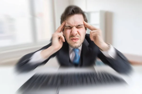 Молодой перегруженный работой человек устал от работы с компьютером и головной боли . — стоковое фото
