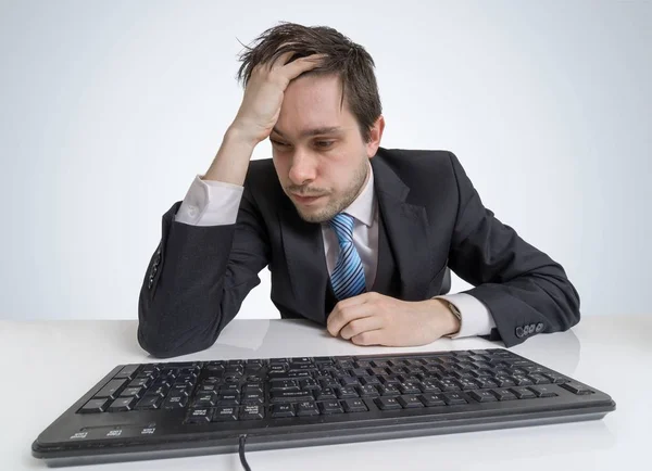 Overworked and exhausted businessman is working with computer. — Stock Photo, Image