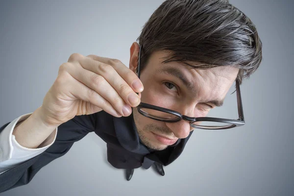 Unga skeptiker man med glasögon tittar på dig. Visa från ovan. — Stockfoto