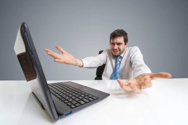 Genç dostum karışık ofiste dizüstü bilgisayar ile çalışma.