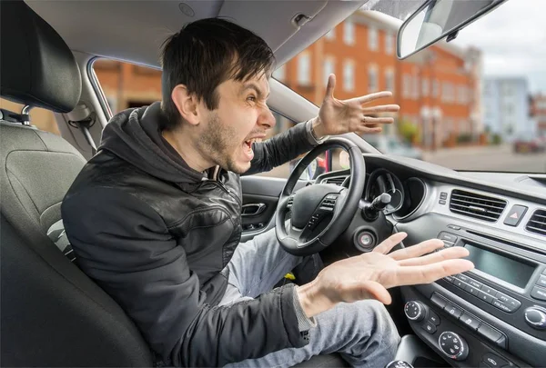 愤怒的年轻司机是驾驶一辆车，大喊. — 图库照片