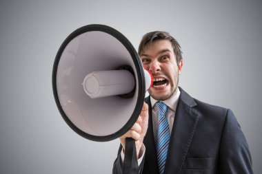 Young businessman is announcing a message and shouting to megaph clipart