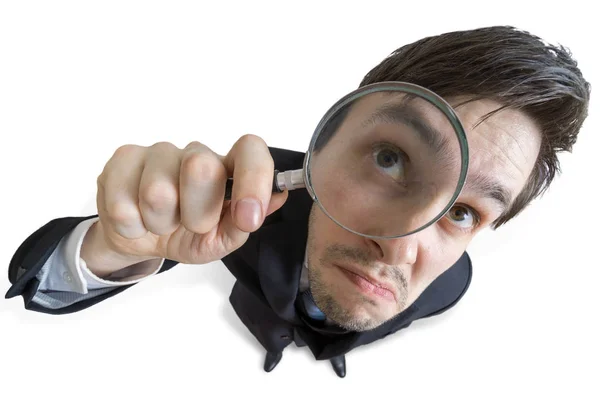 Young businessman is looking through magnifying glass. Isolated — Stock Photo, Image