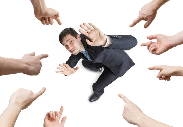 Many hands are pointing and blame stressed man. View from above. — Stock Photo, Image